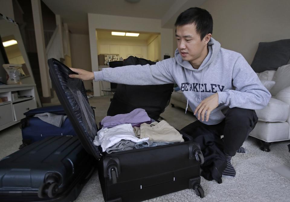 Leo Wang packs a suitcase at his home in San Jose, Calif., on Feb. 4, 2019. Wang has found himself trapped in an obstacle course regarding H-1B work visas for foreigners. (AP Photo/Ben Margot, File)