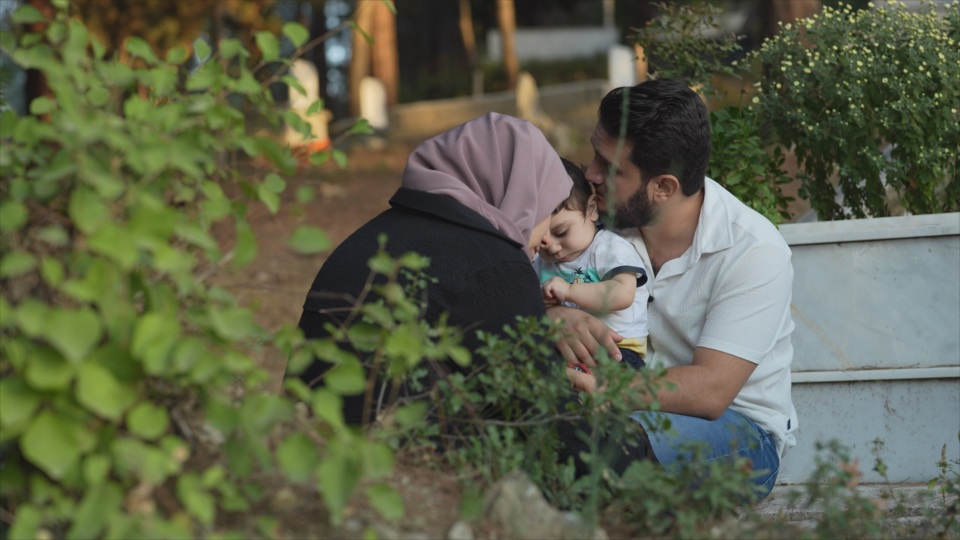 A couple holds their young son, who survived the earthquake; their other young son did not.