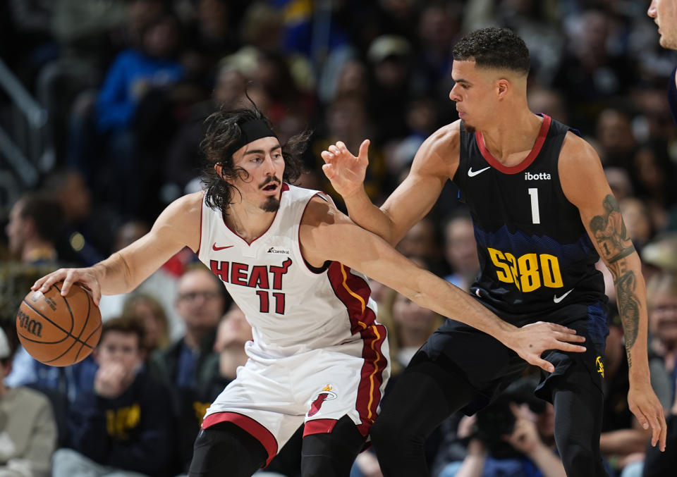 Miami Heat guard Jaime Jaquez Jr., left, looks to pass the ball as Denver Nuggets forward Michael Porter Jr. defends during the second half of an NBA basketball game Thursday, Feb. 29, 2024, in Denver. (AP Photo/David Zalubowski)