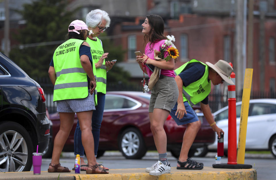 Planned Parenthood volunteer escorts receive the news that abortion services can continue at the clinic following an order from the Missouri Administrative Hearing Commission on Friday, June 28, 2019. The order allows the clinic to continue performing abortions until it takes up its case later this year. (Robert Cohen/St. Louis Post-Dispatch via AP)