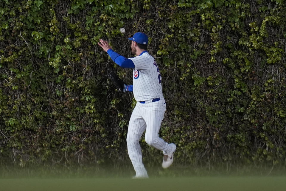 Chicago Cubs center fielder Cody Bellinger struggles to catch a fly ball from Houston Astros' Yainer Diaz as it bounces off the ivy during the fourth inning of a baseball game Tuesday, April 23, 2024, in Chicago. (AP Photo/Erin Hooley)