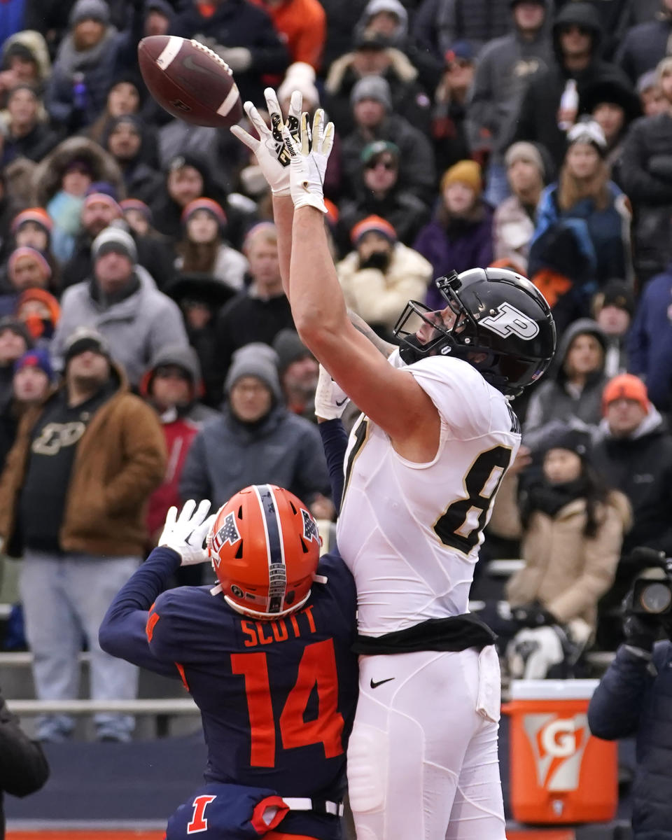 Purdue tight end Payne Durham catches a touchdown pass as Illinois defensive back Xavier Scott defends during the second half of an NCAA college football game Saturday, Nov. 12, 2022, in Champaign, Ill. Purdue won 31-24. (AP Photo/Charles Rex Arbogast)