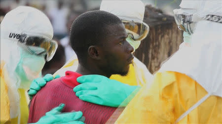 Health workers surround an Ebola patient who escaped from quarantine from Monrovia's Elwa hospital, in the centre of Paynesville in this still image taken from a September 1, 2014 video. REUTERS/Reuters TV