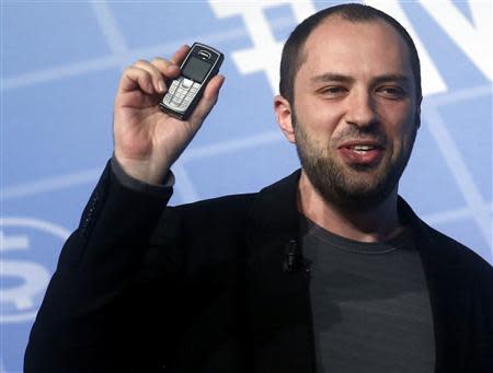 Whatsapp Chief Executive Office and co-founder Jan Koum holds up a mobile phone as he delivers a keynote speech at the Mobile World Congress in Barcelona February 24, 2014. REUTERS/Albert Gea