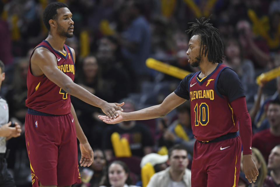 Cleveland Cavaliers center Evan Mobley, left, and guard Darius Garland slap hands in the second half of an NBA basketball game against the Milwaukee Bucks, Sunday, April 10, 2022, in Cleveland. The Cavaliers won 133-115. (AP Photo/David Dermer)