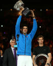 Djokovic lifts the trophy as Murray looks on.