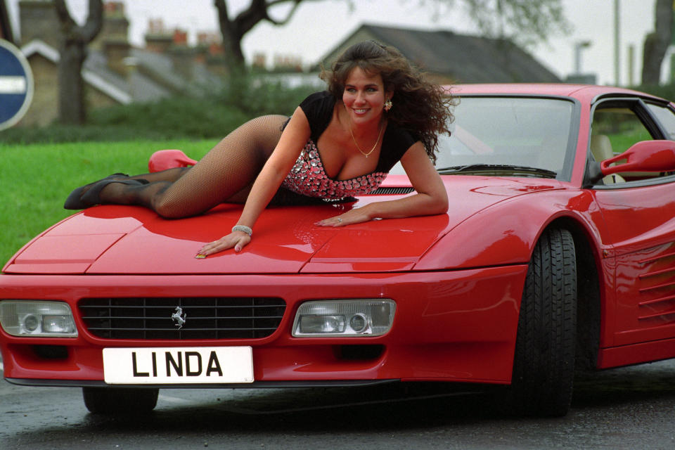 Lying on a Ferrari, Linda Lusardi poses with the number plate L1 NDA, which is to be auctioned at the DVLA classic collection sale   (Photo by Tim Ockenden - PA Images/PA Images via Getty Images)