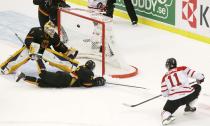 Canada's Bo Horvat (R) scores on Germany's goalie Marvin Cupper and Dominik Kahun during the first period of their IIHF World Junior Championship ice hockey game in Malmo, Sweden, December 26, 2013. REUTERS/Alexander Demianchuk (SWEDEN - Tags: SPORT ICE HOCKEY)