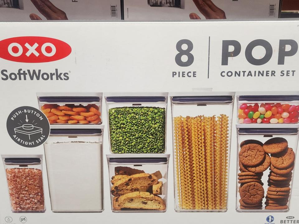Large white box reading "Oxo SoftWorks 8 piece pop container set" with images of clear plastic containers containing biscotti, dried lentils, pasta, jelly beans, and other foods