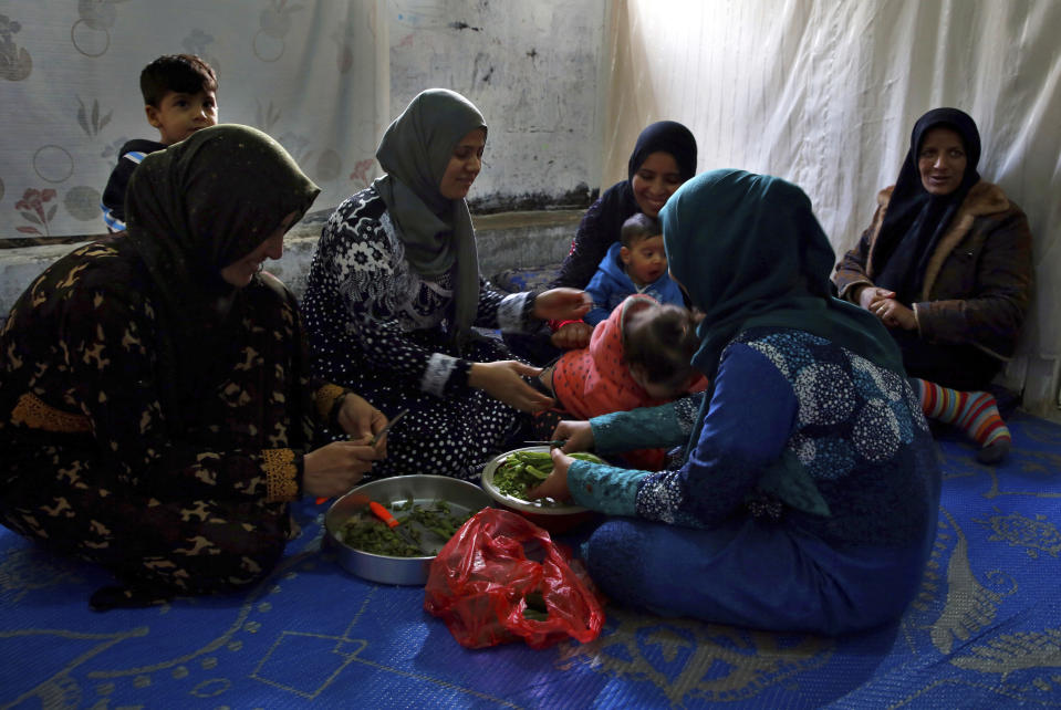 In this Tuesday, Dec. 18, 2018, photo, Syrian refugees women prepare lunch in Ouzai refugee compound, in the southern port city of Sidon, Lebanon. A much touted Russian initiative to facilitate the return of Syrian refugees has fizzled out, with the return of only about 114,000 Syrians - out of more than 5 million in the region and Europe. In Lebanon, which hosts the highest ratio of refugees per capita, most of the estimated 1.2 million Syrians say the intend to stay put, citing economic concerns, ongoing fighting and destroyed homes. (AP Photo/Bilal Hussein)