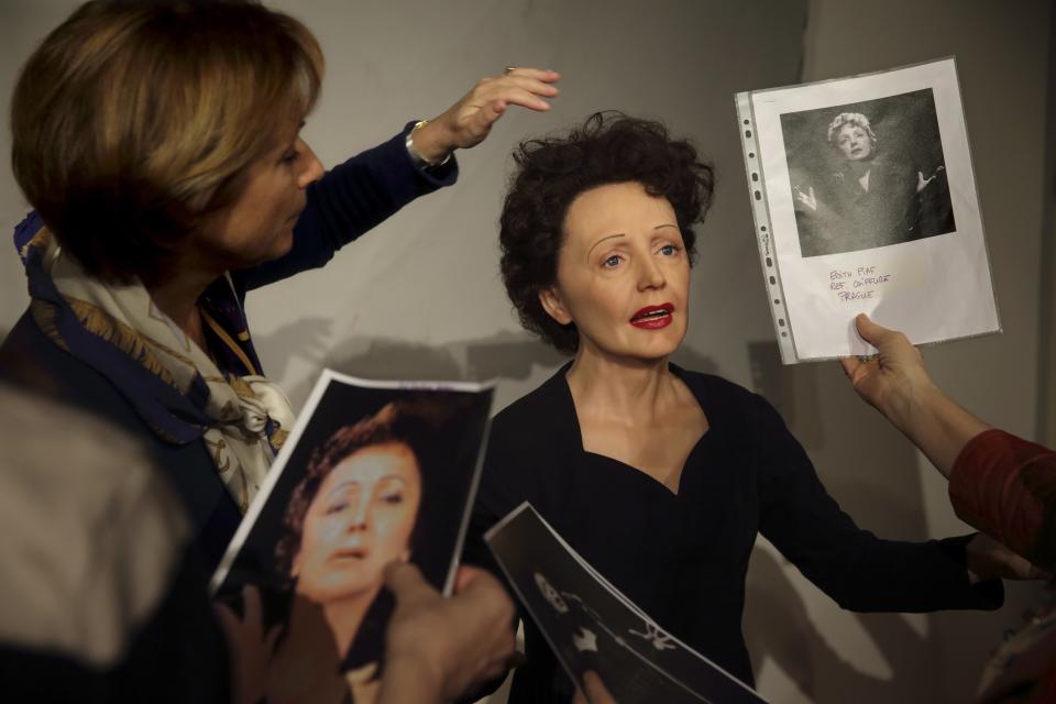 Paris' Grevin Wax Museum staff work around the wax statue of late French singer Edith Piaf in their workshop in Paris