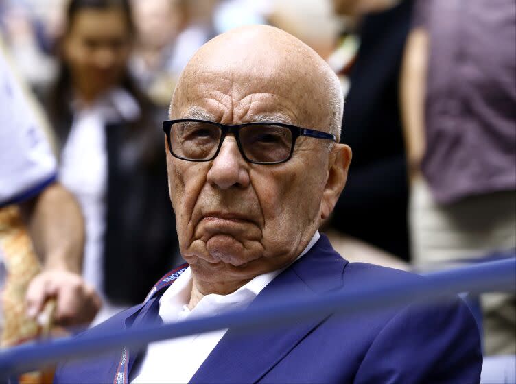 FILE- In this Sunday, Sept. 10, 2017 file photo, Rupert Murdoch waits for the start of the men's singles final of the U.S. Open tennis tournament in New York. Rupert Murdoch's British newspaper company has agreed to pay damages to a former intelligence officer whose computer was hacked by detectives working for Murdoch's now-defunct News of the World tabloid, lawyers said Friday, Oct. 6, 2017. (AP Photo/Julio Cortez, File)