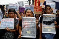Protesters display placards and chant slogans as they march towards the wake of Kian Loyd delos Santos, a 17-year-old high school student, who was among the people shot dead last week in an escalation of President Rodrigo Duterte's war on drugs in Caloocan city, Metro Manila, Philippines August 21, 2017. REUTERS/Erik De Castro