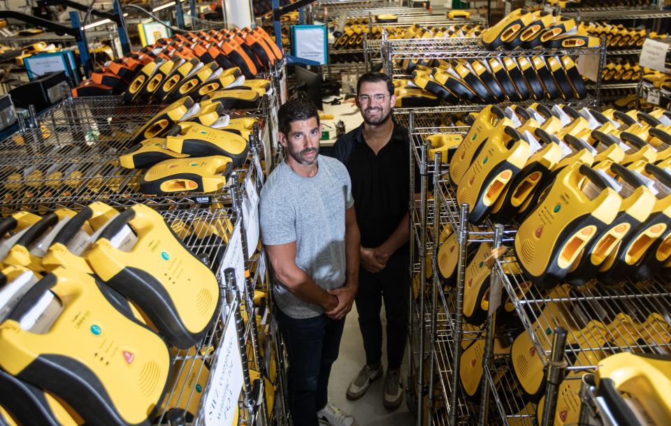 Mike Papale, right, manager of community relations for Defibtech, a company that makes automated external defibrillators (AEDs), and AJ Pace, vice president of global marketing, photographed July 31, 2023, in the company's Branford, Conn., warehouse. The market for AEDs exploded after one was used to help save the life of Damar Hamlin of the Buffalo Bills after he suffered cardiac arrest during a game in January. Papale was also saved by CPR and an AED when he suffered cardiac arrest as a 17-year-old.