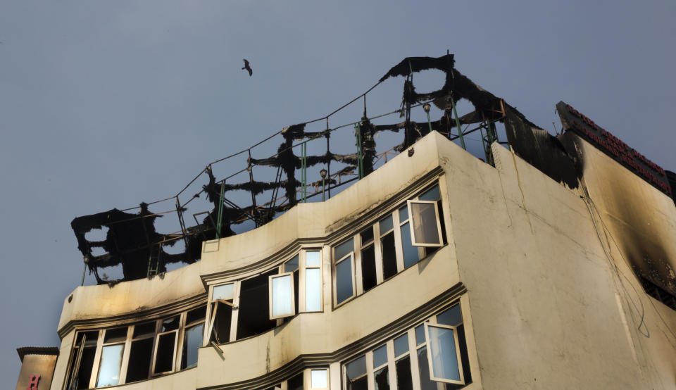 A bird flies above the Arpit Palace Hotel where an early morning fire killed more than a dozen people in the Karol Bagh neighborhood of New Delhi, India, Tuesday, Feb.12, 2019. (AP Photo/Manish Swarup)