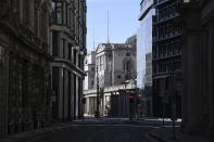 A few people gather outside an otherwise deserted Bank of England in London, Tuesday, March 24, 2020. Britain's Prime Minister Boris Johnson on Monday imposed its most draconian peacetime restrictions due to the spread of the coronavirus on businesses and gatherings, health workers begged for more gear, saying they felt like "cannon fodder." For most people, the new coronavirus causes only mild or moderate symptoms. For some it can cause more severe illness. (AP Photo/Alberto Pezzali)