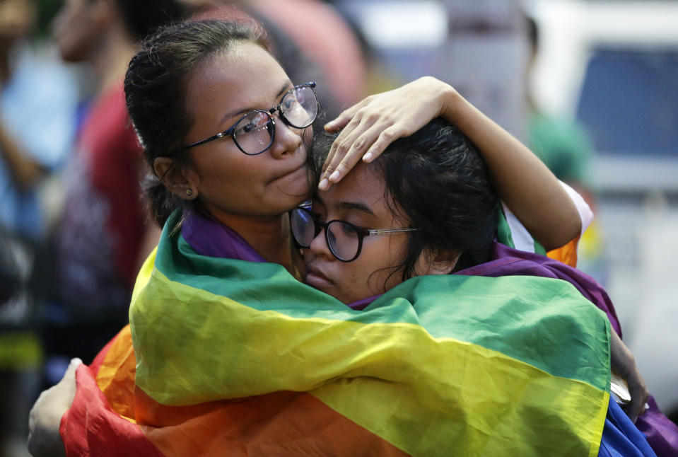 Members of the LGBTQ community embrace each other as they wrap themselves with a rainbow flag during a Pride march outside the Presidential palace in Manila, Philippines on Friday, June 28, 2019 to commemorate the 50th anniversary of the Stonewall riots in New York. The group is also marking the 25th year since the first Pride march in the country as they continue to call for gender equality and same-sex marriage.(AP Photo/Aaron Favila)