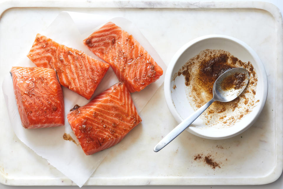 Los filetes de salmón se cubren con una mezcla de ajo y especias antes de dorar. (Beatrix Da Costa/The New York Times)