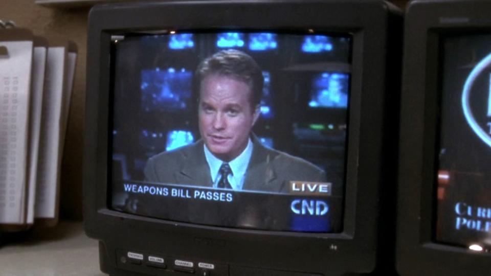 A TV screen shows news anchor Roger Salier (played by Ivan Allen) on an episode of The West Wing.