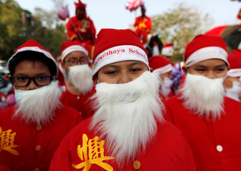 Students dressed in Santa hats and beards take part in a visit to distribute Christmas presents in Ayutthaya