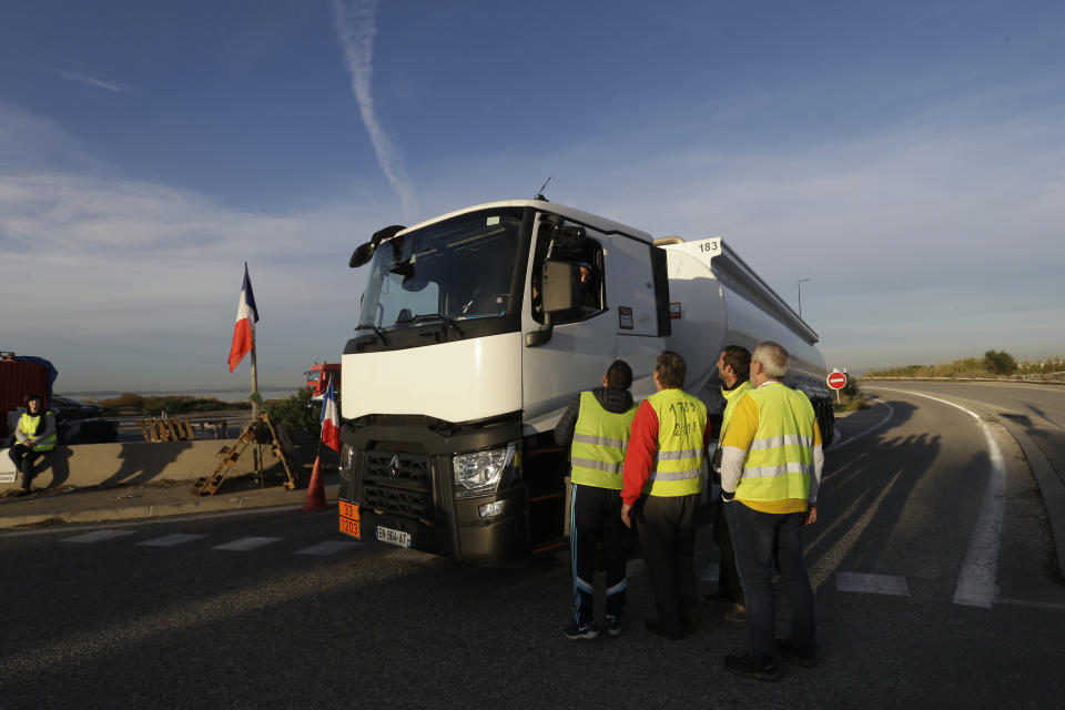 A group of demonstrators wearing their yellow vest talk to a truck driver as they occupy a traffic circle, Wednesday, Dec. 5, 2018 outside La Mede oil refinery, near Martigues, southeastern France. Trade unions and farmers pledged Wednesday to join nationwide protests against President Emmanuel Macron, as concessions by the government failed to stem the momentum of the most violent demonstrations France has seen in decades. (AP Photo/Claude Paris)