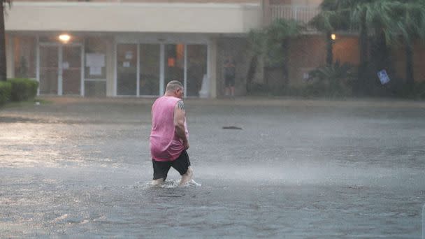 PHOTO: GULF SHORES, ALABAMA - SEPTEMBER 15: A man walks though a flooded parking lot as the outer bands of Hurricane Sally come ashore on September 15, 2020 in Gulf Shores, Alabama.  (Joe Raedle/Getty Images)