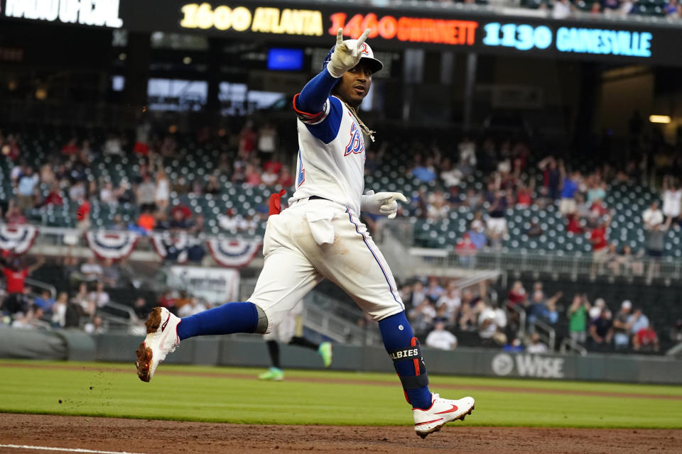 Atlanta Braves' Ozzie Albies (1) gestures as he rounds first base after hitting a home run during the first inning of the team's baseball game against the Miami Marlins on Tuesday, April 13, 2021, in Atlanta. (AP Photo/John Bazemore)