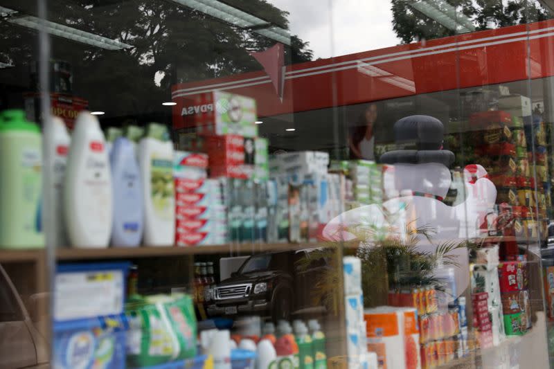 The corporate logo of the Venezuela state oil company PDVSA is seen reflected in the window of a "bodegon" at a gas station in Caracas