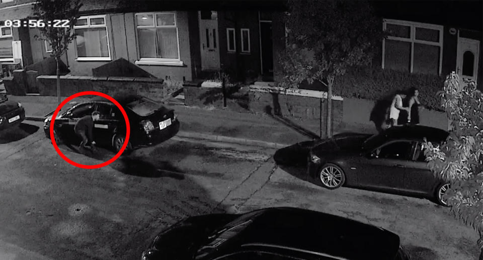 The man hides behind a car as he follows the two women down the street. Source: Facebook