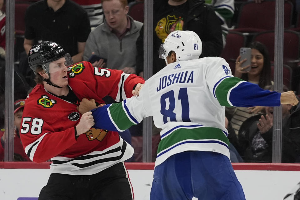 Chicago Blackhawks right wing MacKenzie Entwistle, left, and Vancouver Canucks center Dakota Joshua fight during the third period of an NHL hockey game, Tuesday, Feb. 13, 2024, in Chicago. The Canucks won 4-2. (AP Photo/Erin Hooley)