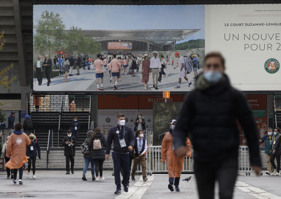 Contraste de imagen de un afiche con la realidad del primer día del Abierto de Francia de tenis, el domingo 27 de septiembre de 2020, en París. (AP Foto/Alessandra Tarantino)