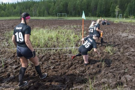 Players of SPA Pirkot and AC Suherot make their way to the swamp field before their ladies' hobby league game at the Swamp Soccer World Championships tournament in Hyrynsalmi, Finland July 13, 2018. Picture taken July 13, 2018. Lehtikuva/Kimmo Rauatmaa/via REUTERS