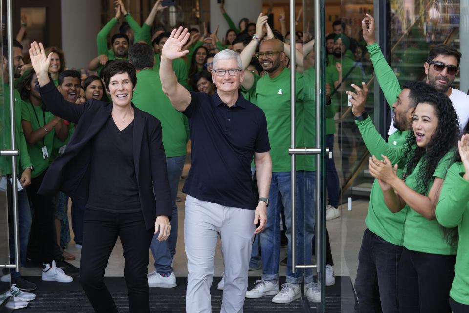 Apple CEO Tim Cook, center, with senior vice president of retail, left, greets people during the opening of the first Apple Inc. flagship store in Mumbai, India, Tuesday, April 18, 2023.  Inc.  It opened its first flagship store in India on Tuesday in a much-anticipated launch that underscores the company's growing ambitions to expand in the country, which it hopes to turn into a potential manufacturing hub.  (AP Photo/Rafiq Maqbool)