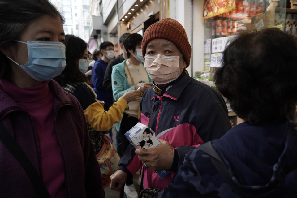 People queue up to buy face masks in Hong Kong, Friday, Feb. 7, 2020. Japan on Friday reported 41 new cases of a virus on a quarantined cruise ship and turned away another luxury liner while the death toll in mainland China rose to 636, including a doctor who got in trouble with authorities in the communist country for sounding an early warning about the disease threat. (AP Photo/Kin Cheung)