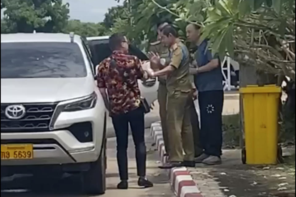 In this UGC image made from video by a source wishing to remain anonymous, one of the two activists, left, travelling with Chinese rights lawyer Lu Siwei, right, argues with police who were in the process of detaining Lu, near the Thanaleng dry port, 13 kilometers (8 miles), south of Vientiane Friday, July 28, 2023. Lu attempted to reach nearby Thanaleng station, to take a train to Thailand. Lawyer Lu, stripped of his license for taking on sensitive cases, has been arrested in the Southeast Asian country of Laos.(Anonymous Source via AP)