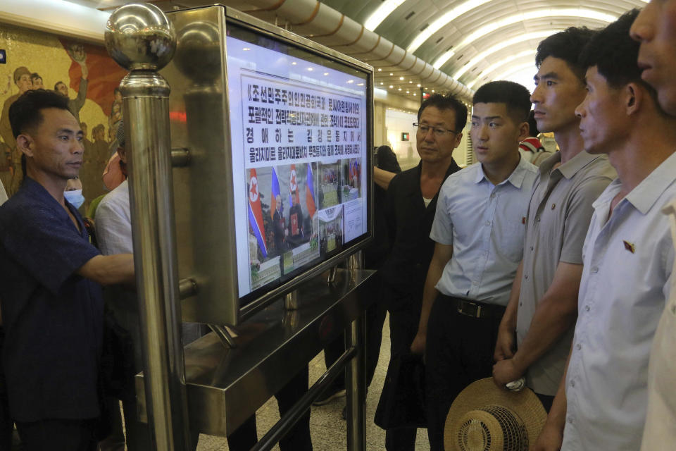 Pyongyang citizens look at news on a ceremony held to welcome Russian President Vladimir Putin, at the Kaeson Station of Pyongyang Metro in Pyongyang, North Korea Thursday, June 20, 2024. (AP Photo/Jon Chol Jin)