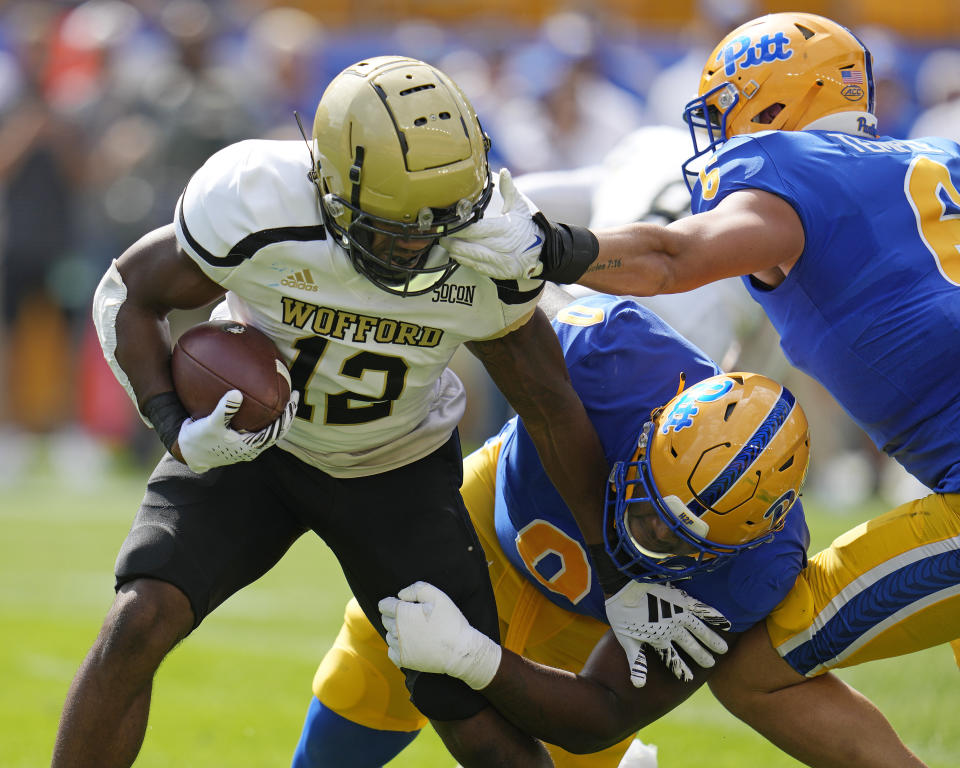 Wofford running back Ryan Ingram, left, is tackled by Pittsburgh defensive lineman Deandre Jules (0) and defensive lineman Nate Temple, right, during the first half of an NCAA college football game in Pittsburgh Saturday, Sept. 2, 2023. (AP Photo/Gene J. Puskar)