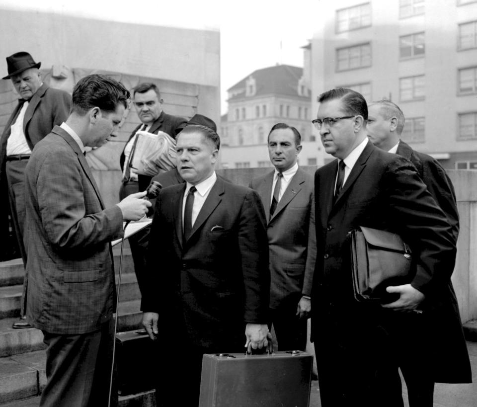 FILE - In this 1964 photo, a reporter questions Teamsters President Jimmy Hoffa outside the federal courthouse in Chattanooga, Tenn., during Hoffa's trial that ended in a jury tampering conviction. The FBI's recent confirmation that it was looking at a spot near a New Jersey landfill as the possible burial site of former Teamsters boss Jimmy Hoffa is the latest development in a search that began when he disappeared in 1975. (Chattanooga Times Free Press via AP, File)