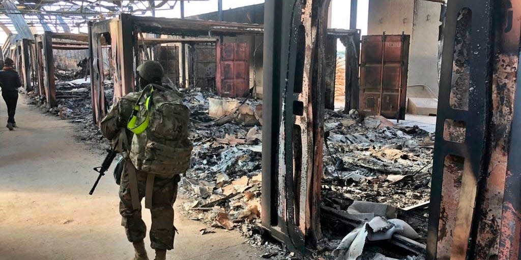 Soldiers walk past a site of Iranian bombing at Ain al-Asad air base, in Anbar, Iraq, Monday, Jan. 13, 2020.