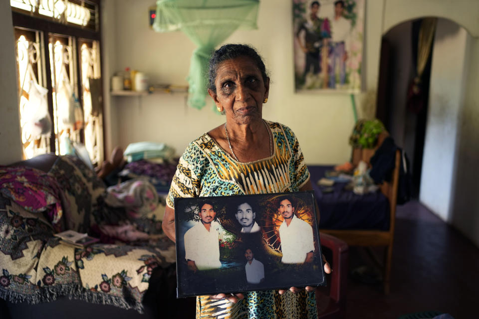 Soosai Victoria, shows photographs of her missing son at her home in Mullaitivu, Sri Lanka, Tuesday, May 7, 2024. "I am praying for him to return, I believe that he is there," said Victoria, who refused to accept a death certificate for her son without information on what actually happened to him. Sri Lanka's civil war, which pitted Sri Lankan government forces against Tamil Tiger separatists, ended 15 years ago but many people are still searching for children or other family members who are missing, some presumed dead. (AP Photo/Eranga Jayawardena)