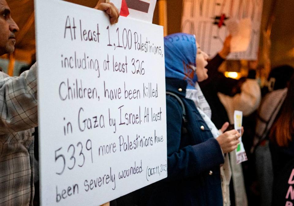 A man holds a sign about the amount of Palestinians killed in Gaza as people gather to show support for Palestine at the Allen Street gates on Thursday, Oct. 12, 2023. Abby Drey/adrey@centredaily.com