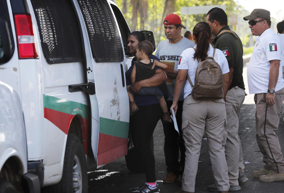 In this May 27, 2019 photo, a migrant woman and her child are detained by Mexican immigration agents at a checkpoint in Tapachula, Chiapas state, Mexico. Washington has demanded Mexico slow a migratory surge of mostly Central Americans fleeing poverty and violence but also Cubans, Haitians and Africans. President Donald Trump has threatened tariffs on Mexican imports may be revived if it doesn't get results. (AP Photo/Marco Ugarte)