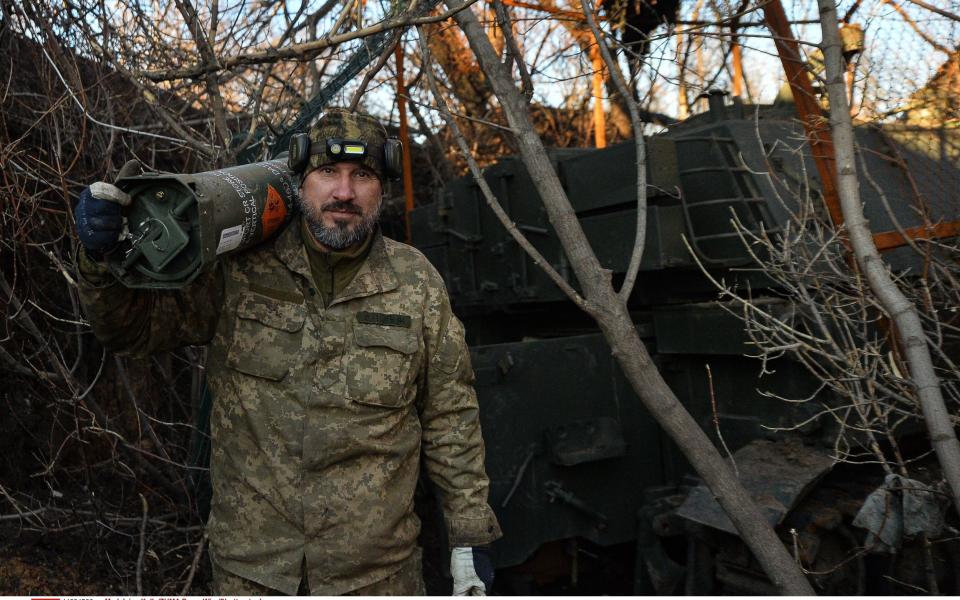A member of a Ukrainian M109 artillery crew prepares ammunition for a current fire mission in the area