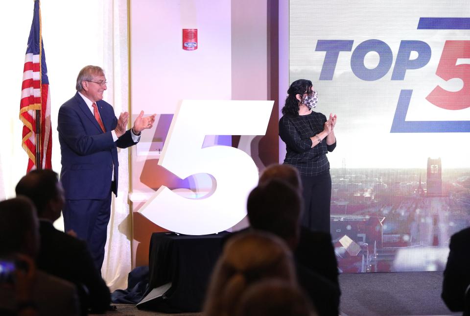 University of Florida president Kent Fuchs, left, and UF professor Alina Zare, right, applaud as they unveil a large five to signify the announcement of UF reaching the top five public universities in the country, during a ceremony at Alumni Hall on the UF campus in Gainesville in 2021.