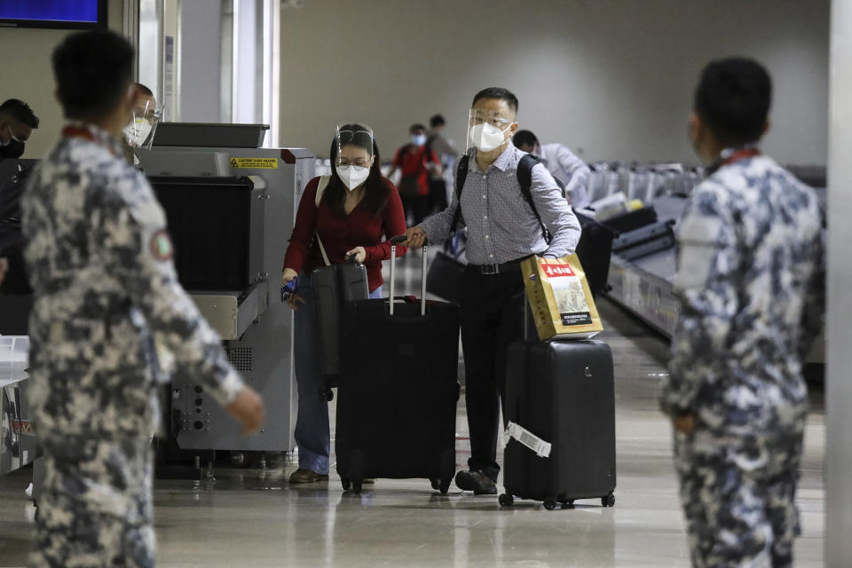 Foreign passengers arrive at Manila's International Airport, Philippines Thursday, Feb. 10, 2022. The Philippines lifted a nearly 2-year ban on foreign travelers Thursday in a lifesaving boost for its tourism and related industries as an omicron-fueled surge eases. (AP Photo/Basilio Sepe)