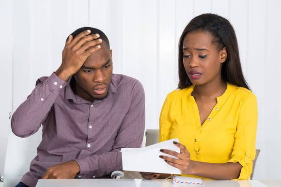 Unhappy couple looking at documents.