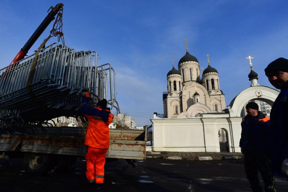 Workers unload metal fencing in front of a church in Moscow where Navalny’s funeral ceremony is set to take place (AFP via Getty Images)