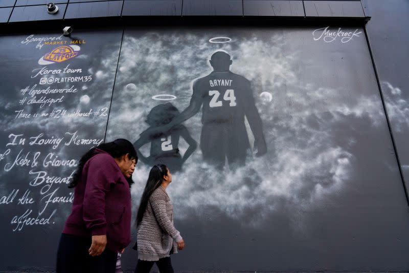 People walk past a mural before the public memorial for NBA great Kobe Bryant, his daughter and seven others killed in a helicopter crash, at the Staples Center in Los Angeles