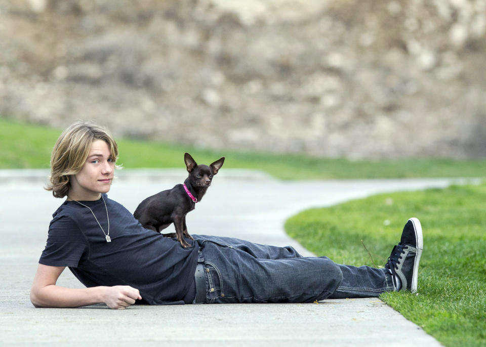 In this Nov. 16, 2012, photo, Lou Wegner, the founder of Kids Against Animal Cruelty, poses for a photo in Burbank, Calif., with his dog Pearl, who was rescued from a shelter. Lou, a 16-year-old actor and singer from Columbus, Ohio, started Kids Against Animal Cruelty when he was 14. The organization, which uses social networking to encourage adoptions at high-kill animal shelters, has helped 20,000 pets escape euthanasia in two years. (AP Photo/Damian Dovarganes)