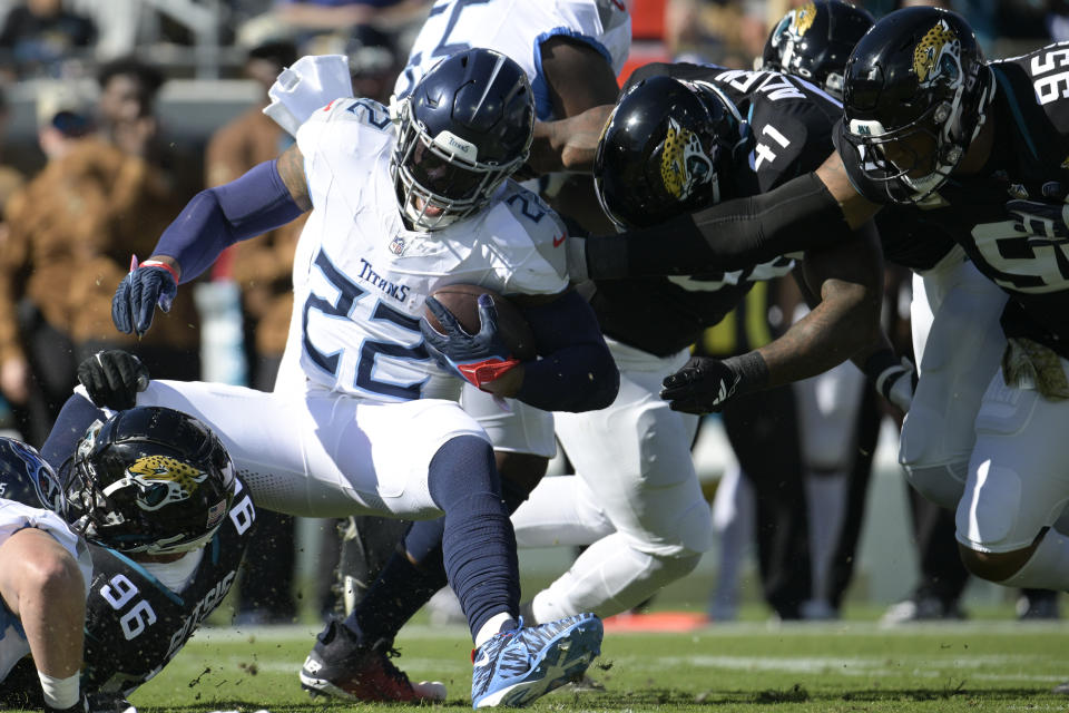 Tennessee Titans running back Derrick Henry (22) is tackled by Jacksonville Jaguars defensive end Adam Gotsis (96), linebacker Josh Allen (41) and defensive end Roy Robertson-Harris (95) during the first half of an NFL football game, Sunday, Nov. 19, 2023, in Jacksonville, Fla. (AP Photo/Phelan M. Ebenhack)